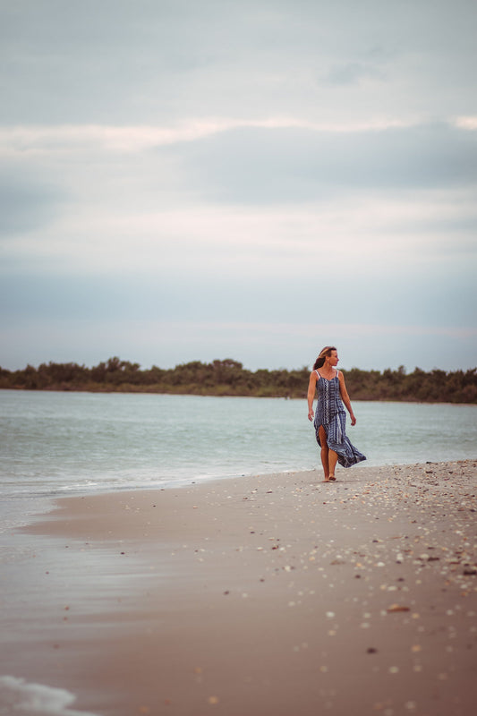 Abbie walking along the coastline with seashells littering the shore.
